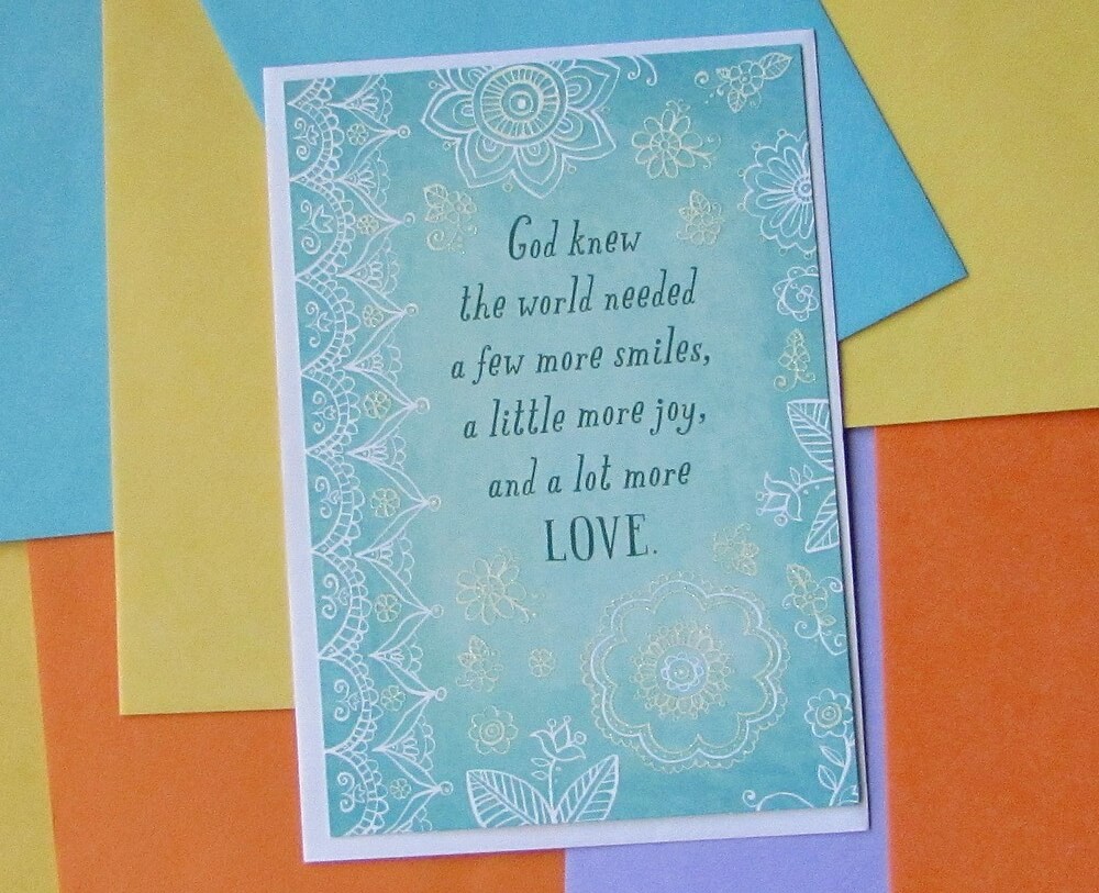 Blue card with white decor; says "God knew the world needed a few more smiles, a little more joy, and a lot more LOVE."