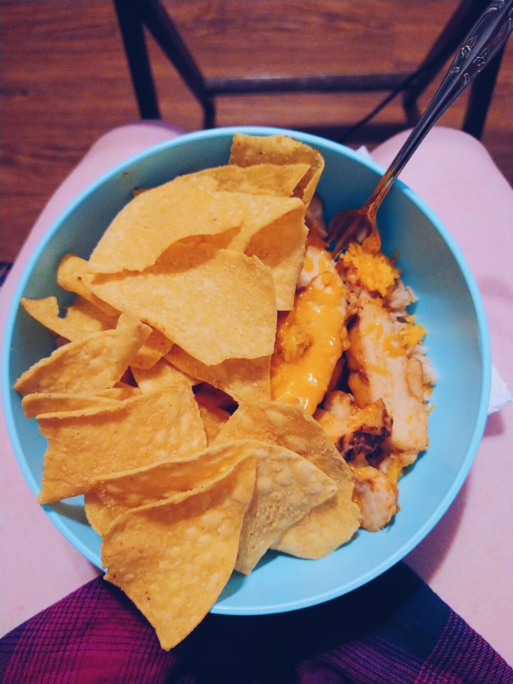 Brown rice, shredded cheese, fajita chicken strips, tortilla chips in aqua bowl