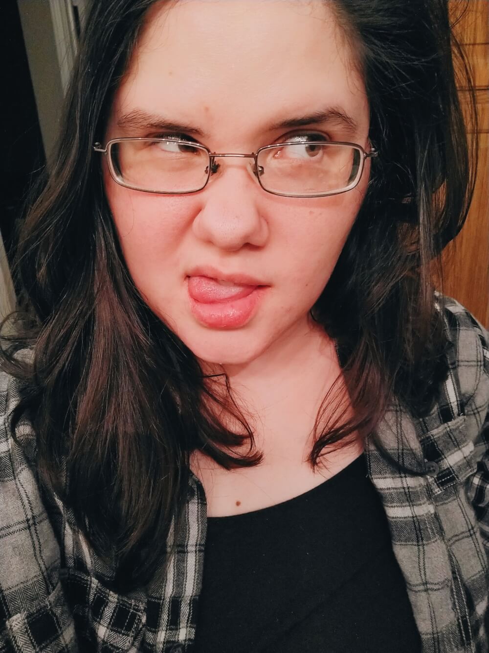 Silly selfie in black plaid flannel with tongue out