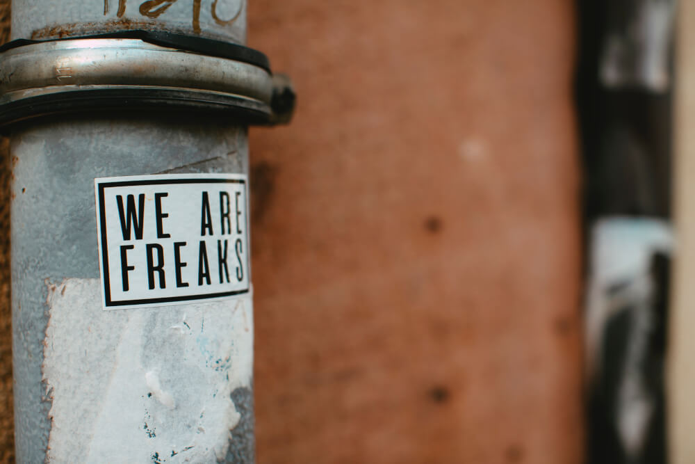 "WE ARE FREAKS" sticker on metal pole